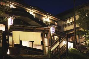 um edifício com luzes de lado à noite em Takamiya Ryokan Miyamaso em Zao Onsen