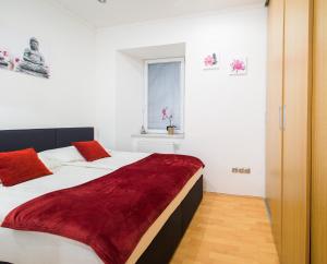een slaapkamer met 2 witte bedden en rode kussens bij Bella Donna in Maribor