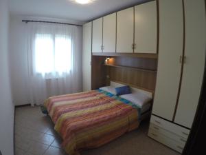 カオルレにあるVillaggio Ginestre - Agenzia Cocalのベッドルーム1室(ベッド1台、窓、キャビネット付)