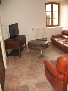 sala de estar con sofá, mesa de centro y sofá en Les Gites Du Chardon, en Teuillac