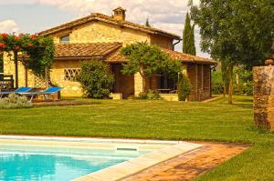 a house with a swimming pool in front of a yard at Monteriggioni Suite in Monteriggioni
