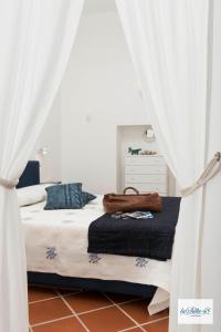 una camera da letto con letto e tende bianche di La Suite 48 a Vietri