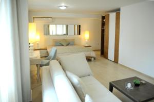 sala de estar con sofá blanco y cama en GreeceRent - ELEGANT Center, en Tesalónica