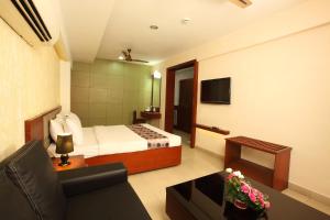 a hotel room with a bed and a couch at Trichur Towers in Trichūr