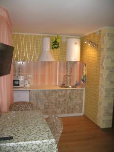 eine Küche mit einem Tisch mit Stühlen und einem Waschbecken in der Unterkunft Уютная квартира ФЕНТЕЗИ in Krywyj Rih