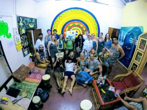 un grupo de personas posando en una habitación con un arco iris en Happy Panda Hostel Arambol Goa en Arambol