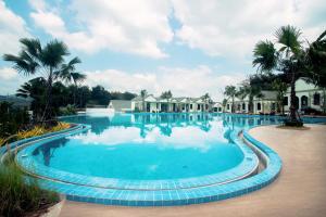 a large pool with blue water and palm trees at Saichon Grand View in Ban Lam Rua Taek