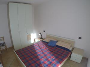 a bedroom with a bed with a plaid blanket at Residence Marina Blu - Agenzia Cocal in Caorle