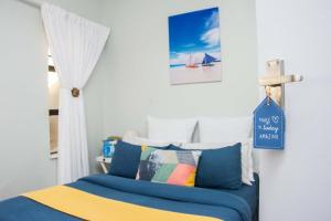 a bedroom with a bed with a sign on the wall at Sea View Holiday Flat - 16 La Luce Margate in Margate +46 photos