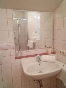 a white bathroom with a sink and a mirror at Appartement Bruckberg in Zell am See +11 photos