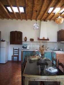 eine Küche mit einem Tisch mit Stühlen und eine Küche mit einer Theke in der Unterkunft El Huerto de Lobras in Lobras