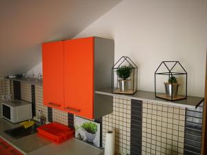 a kitchen with orange cabinets and potted plants at Niko Apartment in Zadar