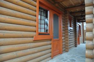 Private Villa 4 Seasons في بيرهوف: باب خشبي على جانب منزل خشبي