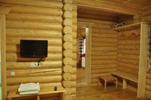 Private Villa 4 Seasons في بيرهوف: غرفة مع تلفزيون على جدار خشبي