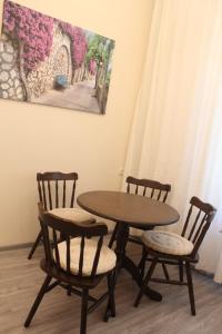 ヴィーンヌィツャにあるApartments on Gogolyaのテーブルと椅子2脚、テーブルと絵画