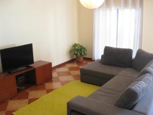 a living room with a couch and a flat screen tv at Casa Maresia in Ponta do Sol
