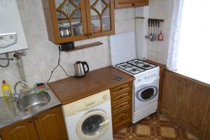 a small kitchen with a washing machine and a sink at Apartment on Kniaziv Koriatovychiv 9 in Kamianets-Podilskyi