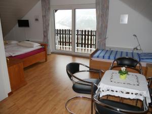 Zimmer mit einem Tisch, Stühlen und einem Bett in der Unterkunft Ferienwohnung Gerstmann in Wenholthausen