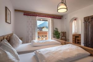 2 łóżka w sypialni z oknem w obiekcie Alpenhostel "Das Besenhaus" w mieście Altenmarkt im Pongau
