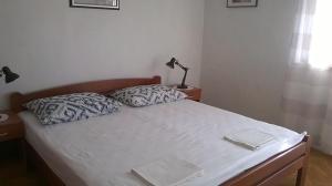 斯塔里格勒的住宿－Apartments Rade，一张带两个枕头的床和一盏灯