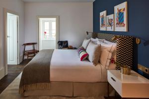 um quarto com uma cama grande e paredes azuis em The Lumiares Hotel & Spa - Small Luxury Hotels Of The World em Lisboa