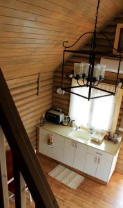 een keuken met een wastafel en een kroonluchter bij דליה ברמה -אירוח כפרי צמחוני in El-Rom