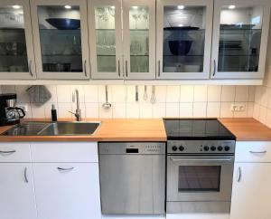 eine Küche mit weißen Schränken und einem Waschbecken in der Unterkunft The Kreideberger - Haus mit Platz in Lüneburg
