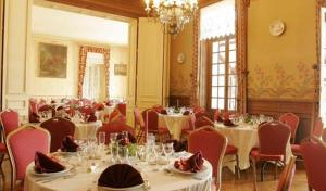 Un comedor con mesas y sillas y una lámpara de araña. en Château de Montbraye, en Parigné-lʼÉvêque 38 fotos más