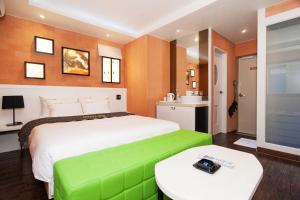 a bedroom with a large bed with a green bench at Apple Drive-in Hotel in Yeoju