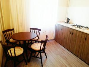 ヴィーンヌィツャにあるApartments on Gogolyaのキッチン(テーブル、椅子、シンク付)
