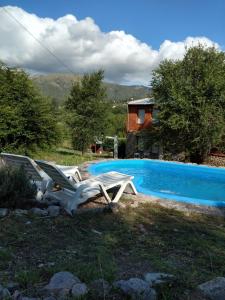2 sillas de jardín sentadas junto a una piscina en La Loma en Villa Giardino