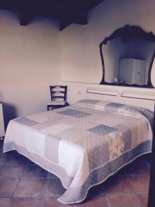 una camera con un grande letto e una sedia di The Cottage ad Agerola