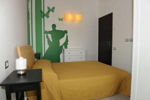 1 dormitorio con 1 cama y una pared verde y blanca en Casale Papa Country Village en Loreto