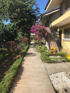 a sidewalk in front of a house with pink flowers at Sweet Dreams in Coco