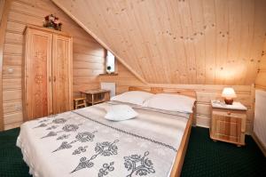 ザコパネにあるグラルスキ ドメク ハヌシナ コンチナの木造キャビン内のベッド1台が備わるベッドルーム1室を利用します。
