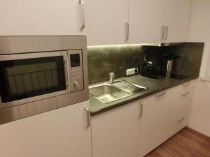 uma cozinha com um lavatório e um micro-ondas em Ausblick em Längenfeld