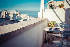 a table and chairs on a balcony with a view of a city at Via Roma in Ostuni