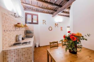 a kitchen with a table with a vase of flowers at Hotel Anfiteatro Flavio in Rome