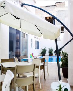 een witte paraplu bovenop een tafel bij 8villa in St Julian's