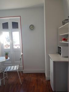 une chambre avec une table, une chaise et une fenêtre dans l'établissement Le Béarn sous les toits, à Nay