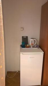 a small white refrigerator in a corner of a room at Room Rade in Stari Grad