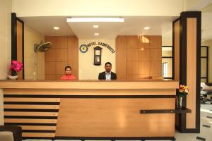 2 persone sedute al bancone nella hall di un hotel di Hotel Rainforest a Sauraha