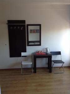 グディニャにあるLux Hostel - z prywatnymi łazienkamiのテーブル、椅子2脚、鏡が備わる客室です。