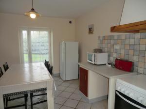 una cucina con un tavolo e un frigorifero bianco di Le Refuge a Champagné-Saint-Hilaire