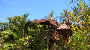 een oud huis in de jungle met palmbomen bij Le Logis de Kep in Kep