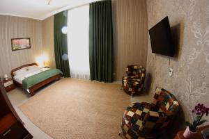 een hotelkamer met een bed en een televisie bij Гостевой дом НИК in Charkov