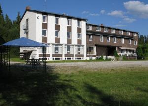 un gran edificio con un paraguas azul delante de él en Tronsvangen Seter, en Alvdal