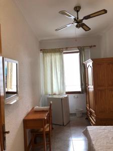 Habitación con nevera, mesa y ventana en Casa de Huespedes el Almendro, en Ibiza