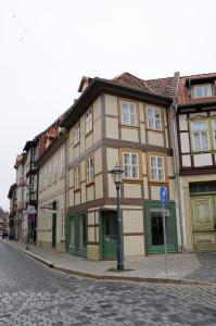 un edificio marrón y verde en una calle de la ciudad en Apartments am Brunnen, en Quedlinburg