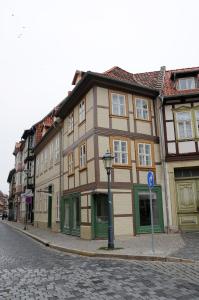 ein braunes und grünes Gebäude in einer Stadtstraße in der Unterkunft Apartments am Brunnen in Quedlinburg